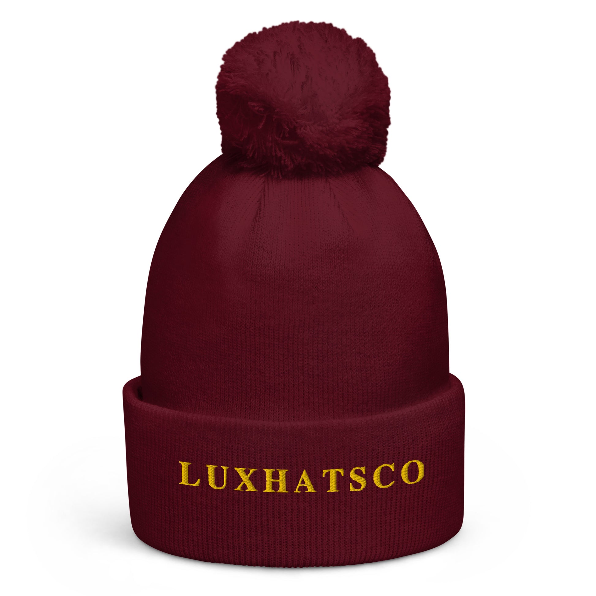 A maroon-colored beanie with a pom pom on top, featuring the text 'LUXHATSCO' on the fold.